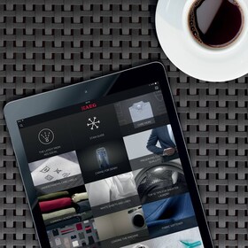 Мъж, който задава температурата на паровата си фурна, използвайки смартфона си и приложението My AEG