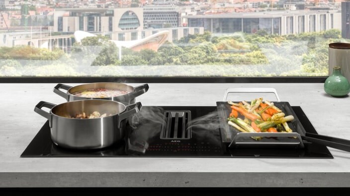 Индукционен плот с аспиратор в кухня с изглед към града