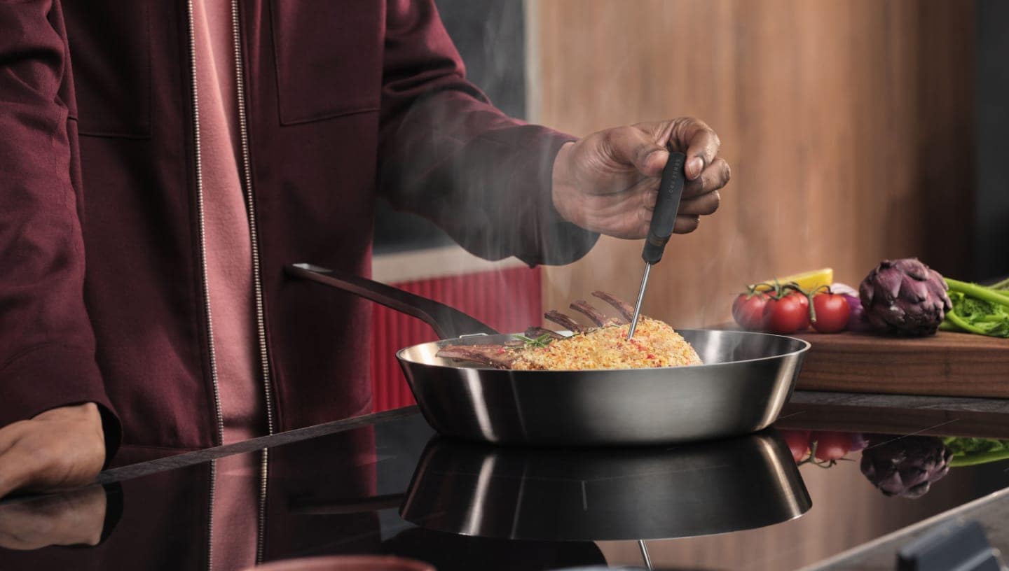 Човек приготвя храна на индукционен плот.