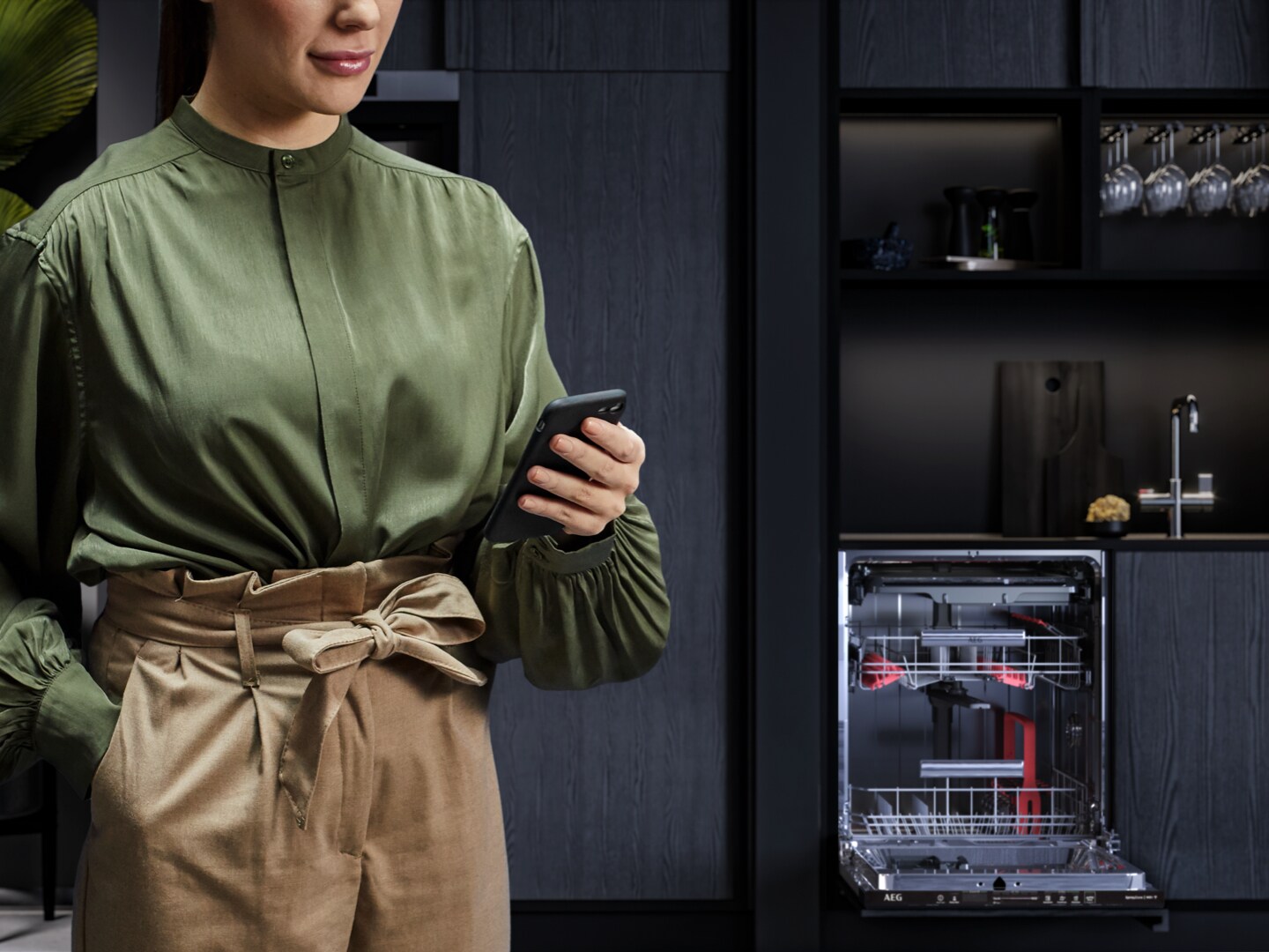 Woman holding phone in kitchen