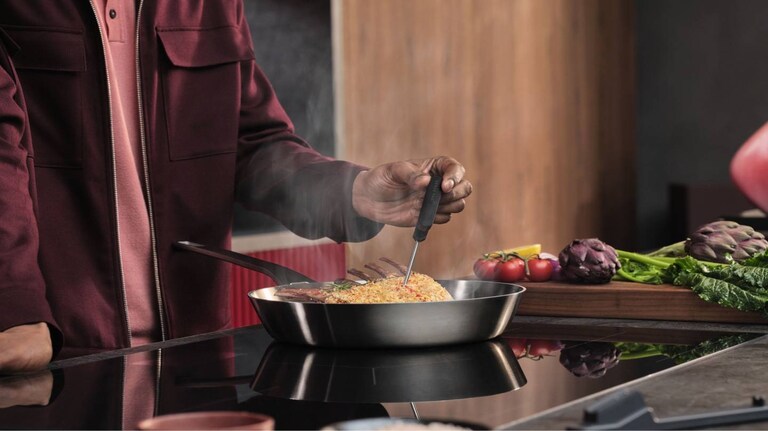 Мъж приготвя храна на плот.